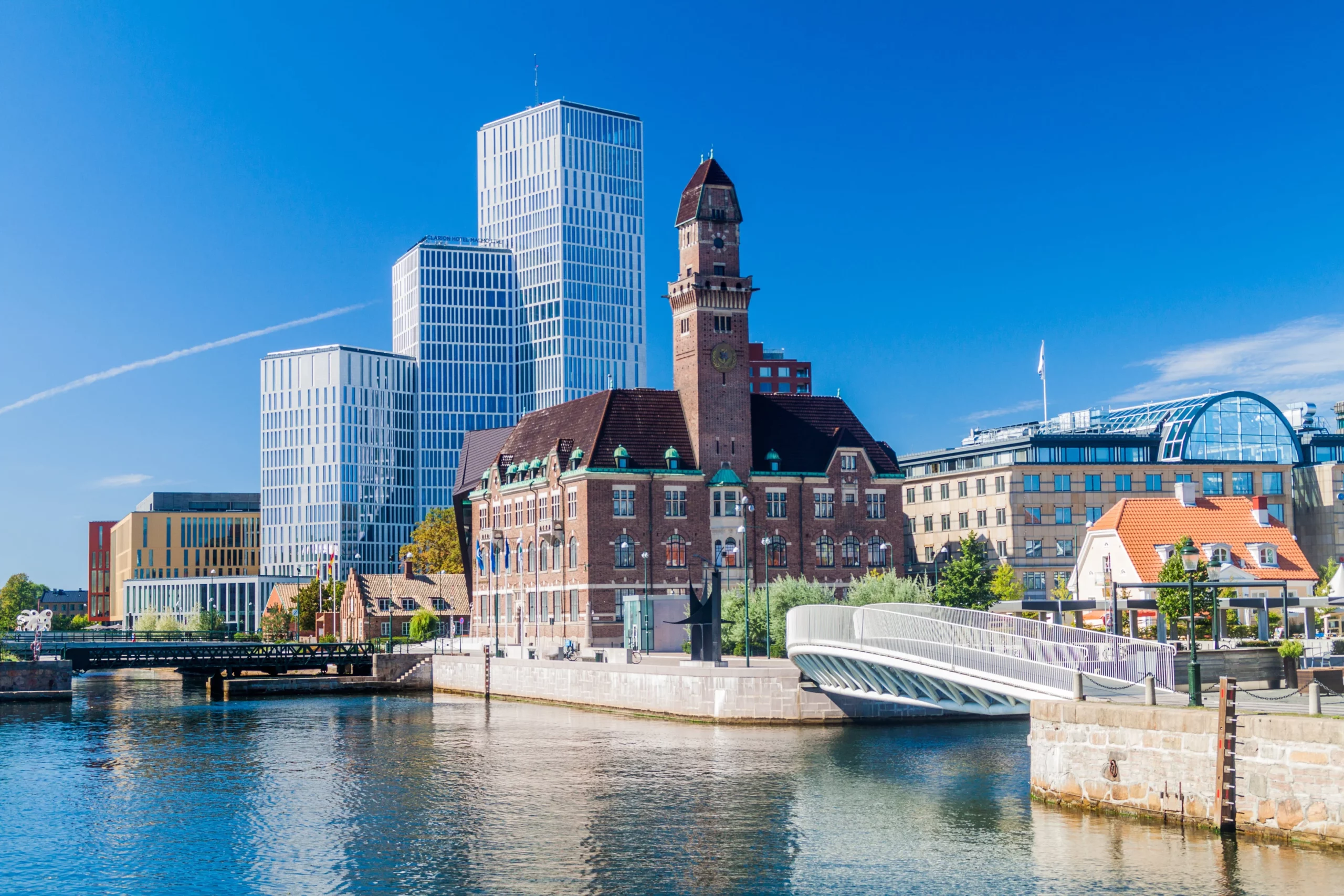 Vy över centrala Malmö med moderna byggnader och bro över kanalen.